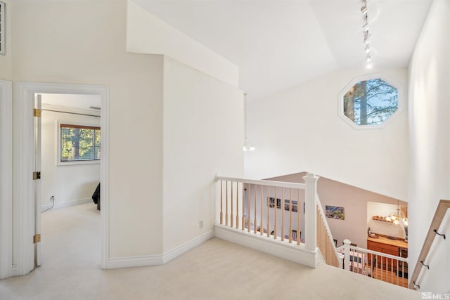 interior space featuring lofted ceiling, a notable chandelier, and light carpet