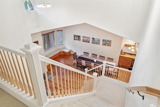 staircase with lofted ceiling and a chandelier