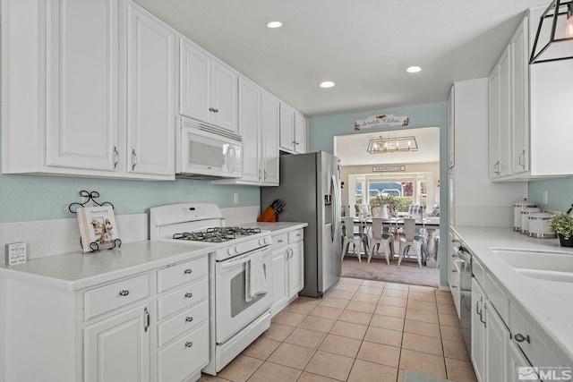 kitchen featuring white cabinetry, white appliances, and light tile patterned floors