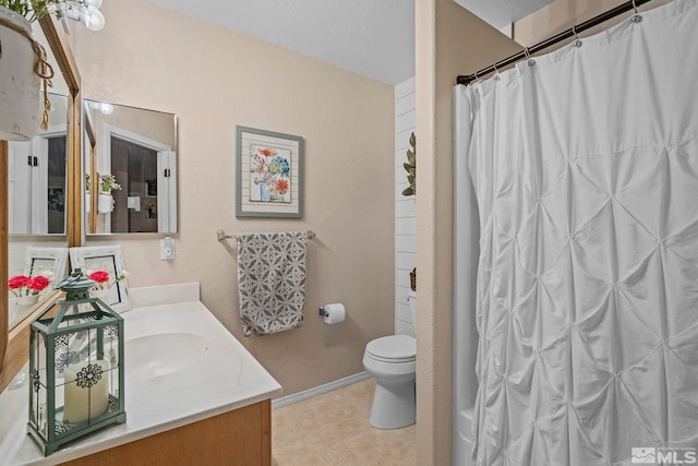 bathroom with vanity, toilet, and curtained shower