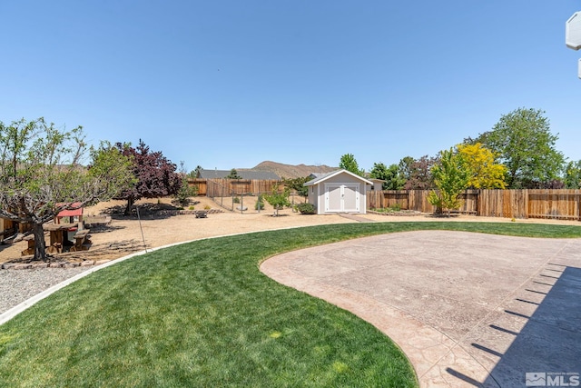 view of yard with a patio, a mountain view, and a shed