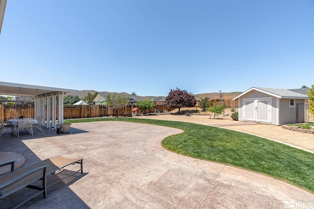 view of patio / terrace with a storage shed and a mountain view