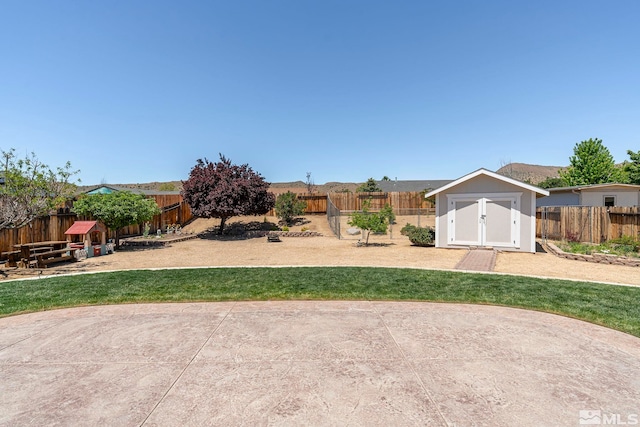 view of yard featuring a storage shed and a patio