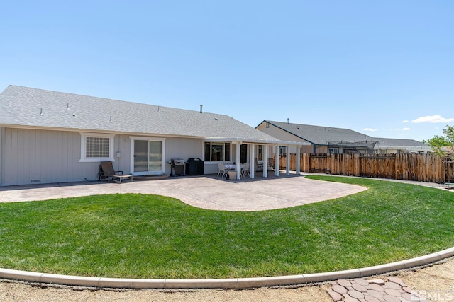 back of house featuring a patio area and a lawn