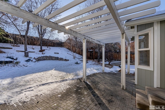 snow covered patio featuring a pergola