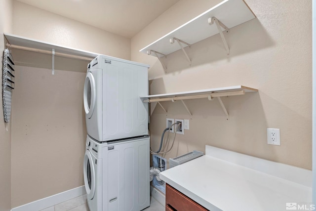 laundry room with light tile patterned floors and stacked washer / dryer