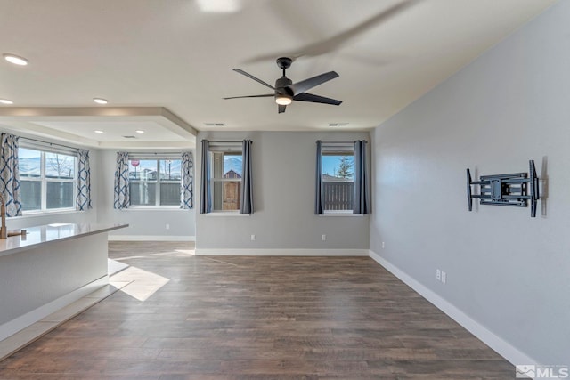 empty room featuring dark wood-type flooring and ceiling fan