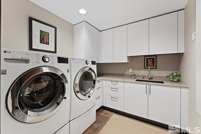 washroom featuring cabinets, independent washer and dryer, and sink