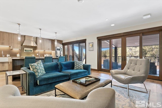 living room featuring sink and light hardwood / wood-style floors