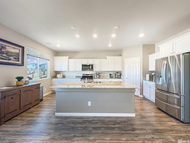 kitchen featuring stainless steel appliances, dark hardwood / wood-style floors, a center island with sink, and white cabinets