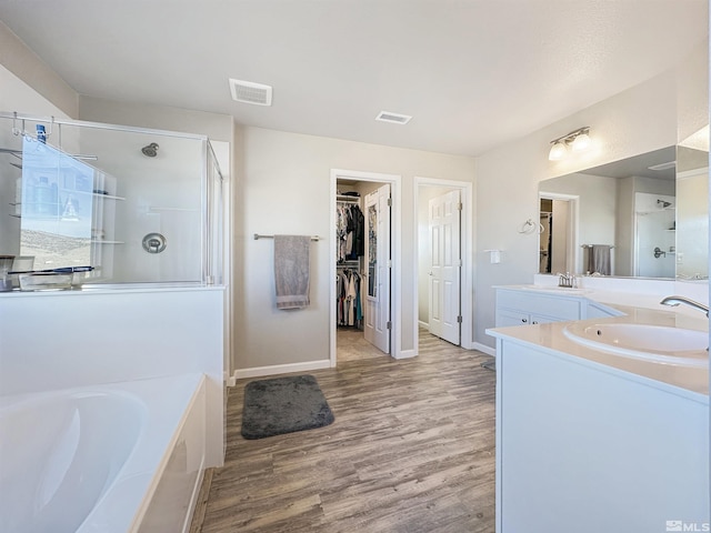 bathroom featuring vanity, wood-type flooring, and separate shower and tub