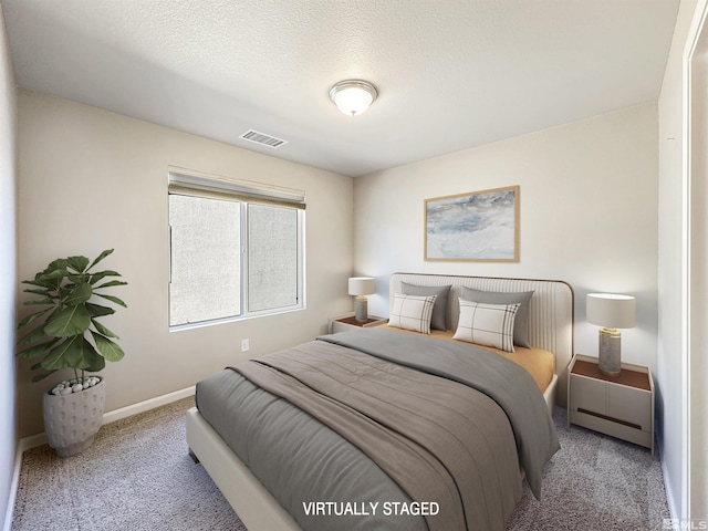 bedroom featuring light colored carpet and a textured ceiling