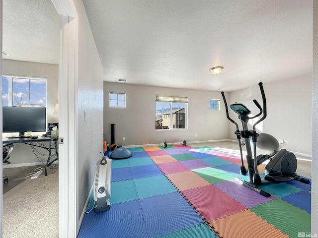 exercise area featuring a textured ceiling