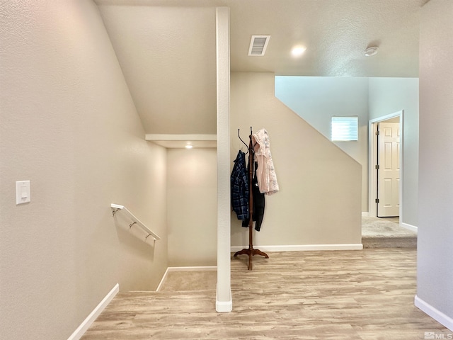 stairway featuring hardwood / wood-style flooring and a textured ceiling