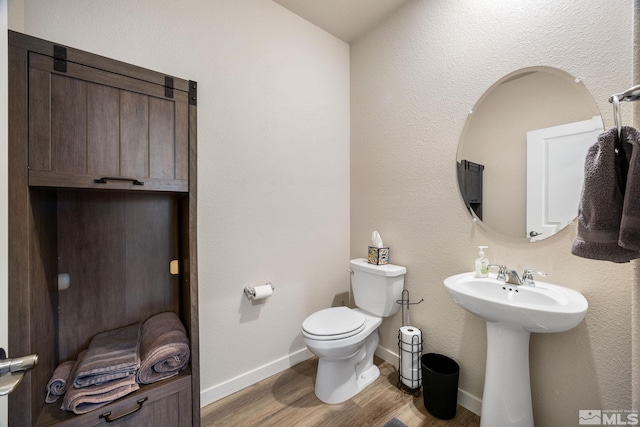 bathroom with hardwood / wood-style floors, sink, and toilet