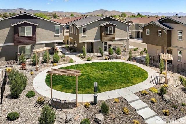 surrounding community with a mountain view and a lawn