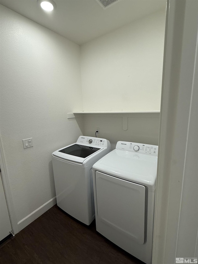 laundry room featuring dark hardwood / wood-style floors and washing machine and dryer