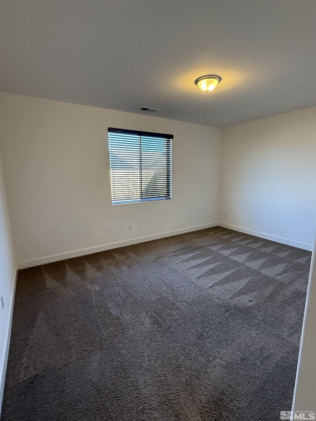 unfurnished room featuring dark carpet