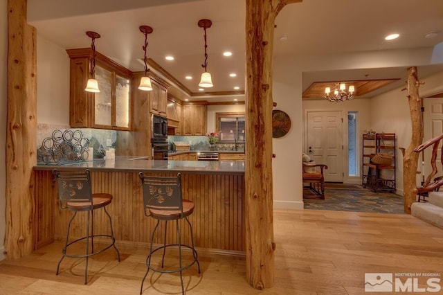 kitchen with a breakfast bar area, kitchen peninsula, built in microwave, decorative backsplash, and oven