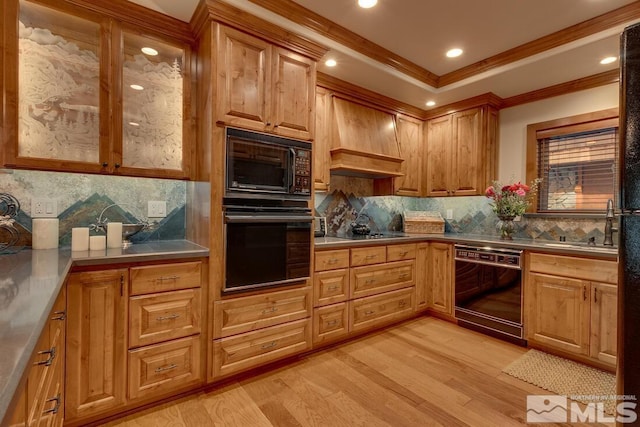 kitchen with premium range hood, tasteful backsplash, ornamental molding, light hardwood / wood-style floors, and black appliances