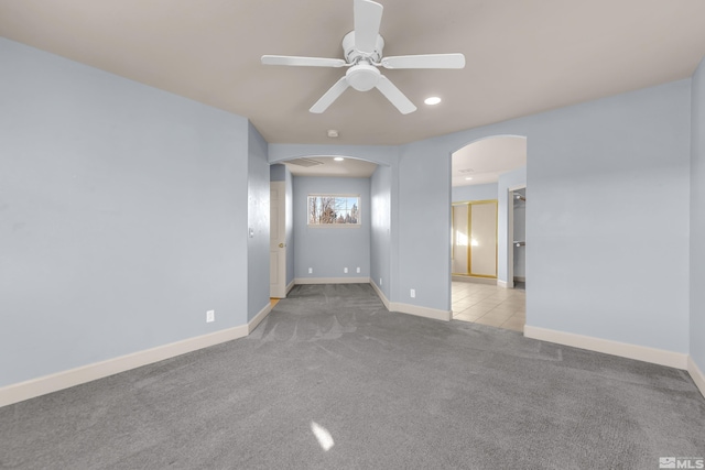 carpeted spare room featuring ceiling fan