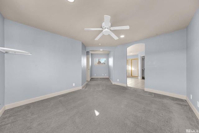 carpeted spare room featuring ceiling fan