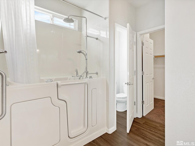 bathroom featuring a shower with curtain, hardwood / wood-style flooring, and toilet