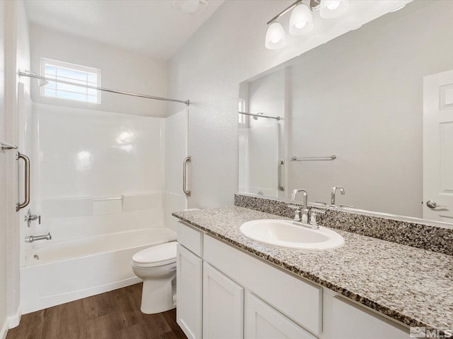 full bathroom with vanity, hardwood / wood-style floors, tub / shower combination, and toilet