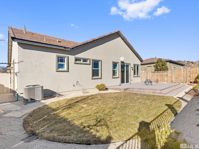 back of house featuring cooling unit, a patio area, and a lawn