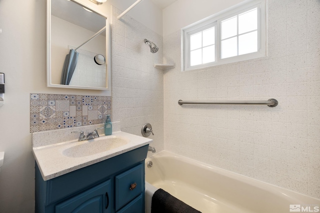 bathroom with vanity, decorative backsplash, and tiled shower / bath