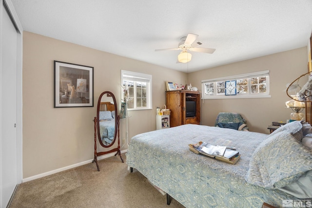 carpeted bedroom featuring a closet and ceiling fan