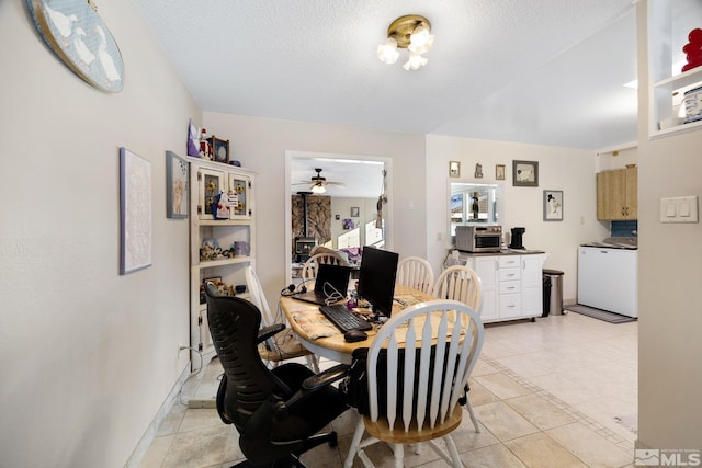 dining space featuring washer / dryer, light tile patterned floors, and a textured ceiling