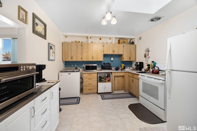 kitchen featuring white appliances, white cabinetry, backsplash, light brown cabinetry, and washer / clothes dryer