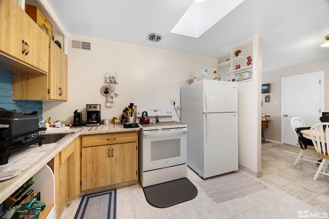 kitchen with light tile patterned floors, white appliances, and a skylight