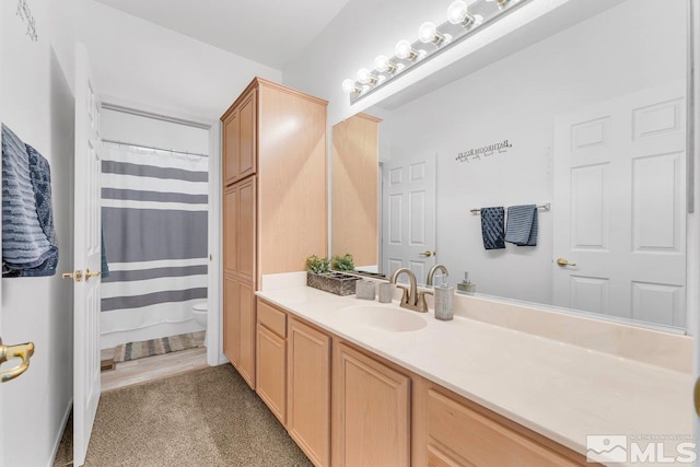 bathroom featuring vanity, toilet, and a shower with shower curtain