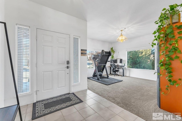 foyer featuring light carpet and a wealth of natural light