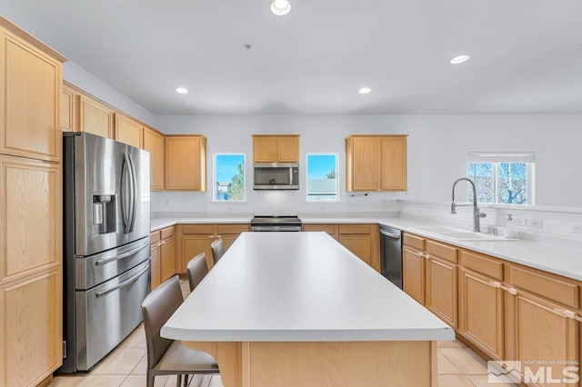 kitchen featuring stainless steel appliances, a center island, a breakfast bar, and sink