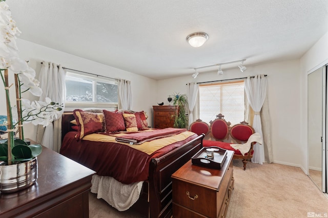 carpeted bedroom featuring multiple windows and a textured ceiling