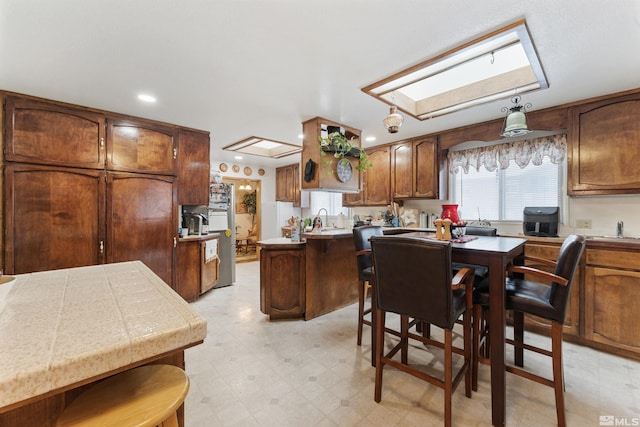 kitchen featuring a kitchen island, sink, and a skylight