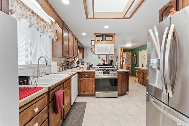 kitchen featuring stainless steel appliances, sink, and a skylight