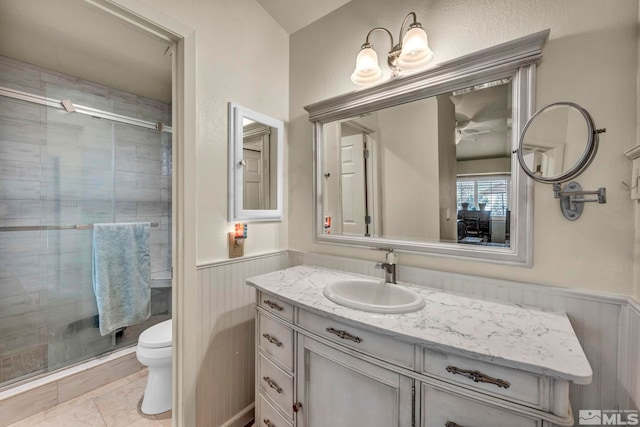 bathroom with tile patterned floors, vanity, toilet, and a shower with door