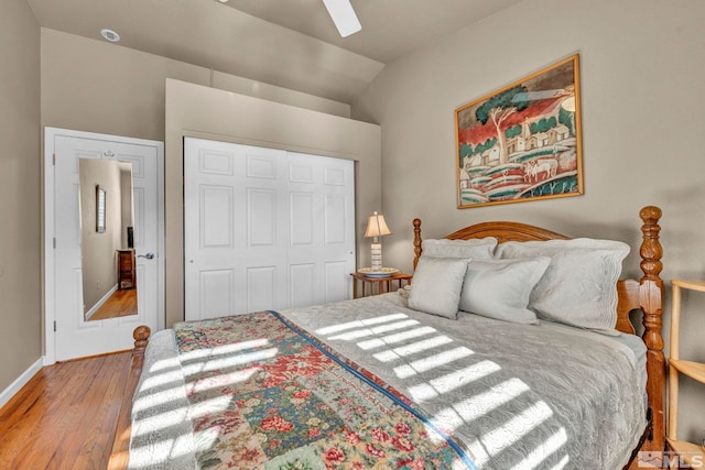 bedroom with lofted ceiling, light hardwood / wood-style flooring, a closet, and ceiling fan