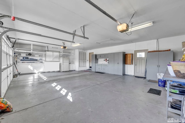 garage with a garage door opener and white fridge