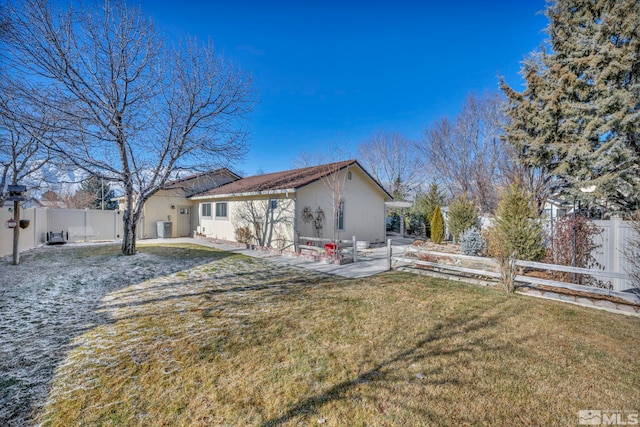 back of house featuring a lawn and a patio area