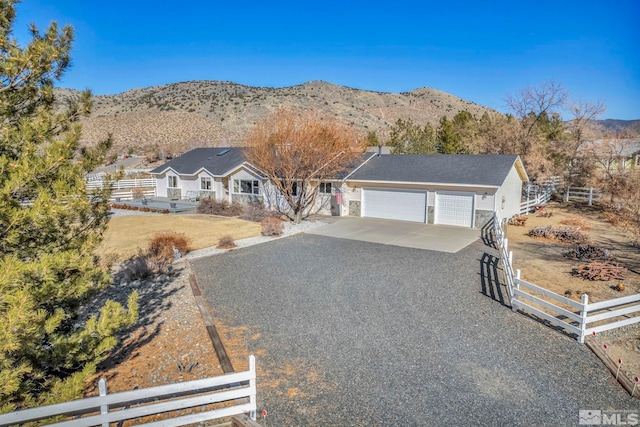 ranch-style home featuring a garage and a mountain view