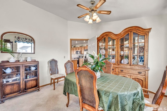 dining space featuring light colored carpet and ceiling fan