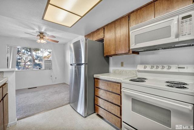 kitchen featuring ceiling fan, white appliances, light carpet, and cooling unit