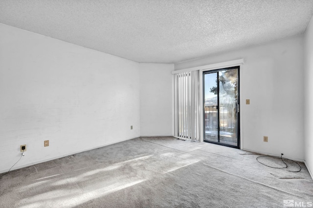 spare room with a textured ceiling and carpet