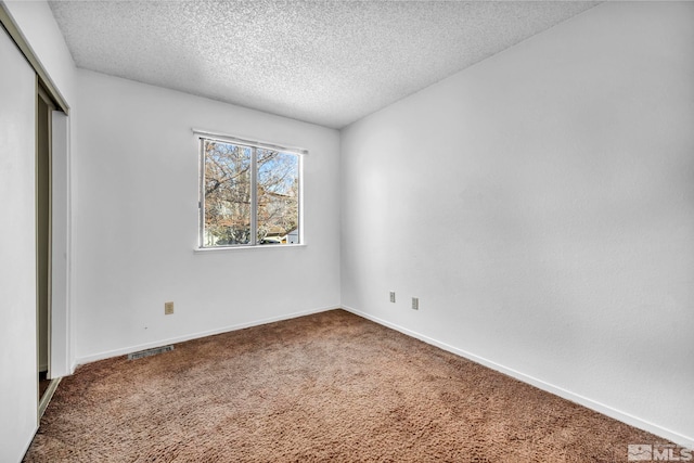 unfurnished bedroom featuring carpet floors, a textured ceiling, and a closet