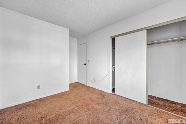 unfurnished bedroom featuring carpet floors, a closet, and a textured ceiling